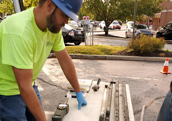 A Creek Run employee leans against a table, examining soil samples.