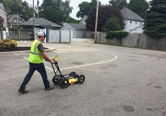 A Creek Run employee drives a Ground Penetrating Radar (which looks similar to a push mower) across a parking lot.