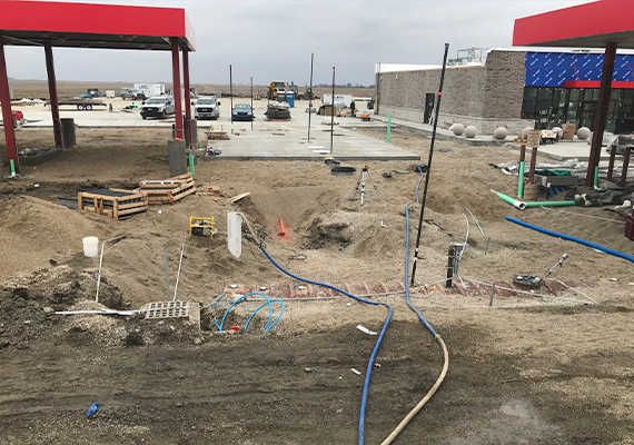 A wide angle view of the construction of a gas station system, where the various pipes and tanks are laid out.
