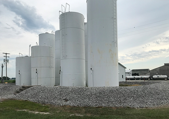 Multiple white silo-style tanks of various heights.